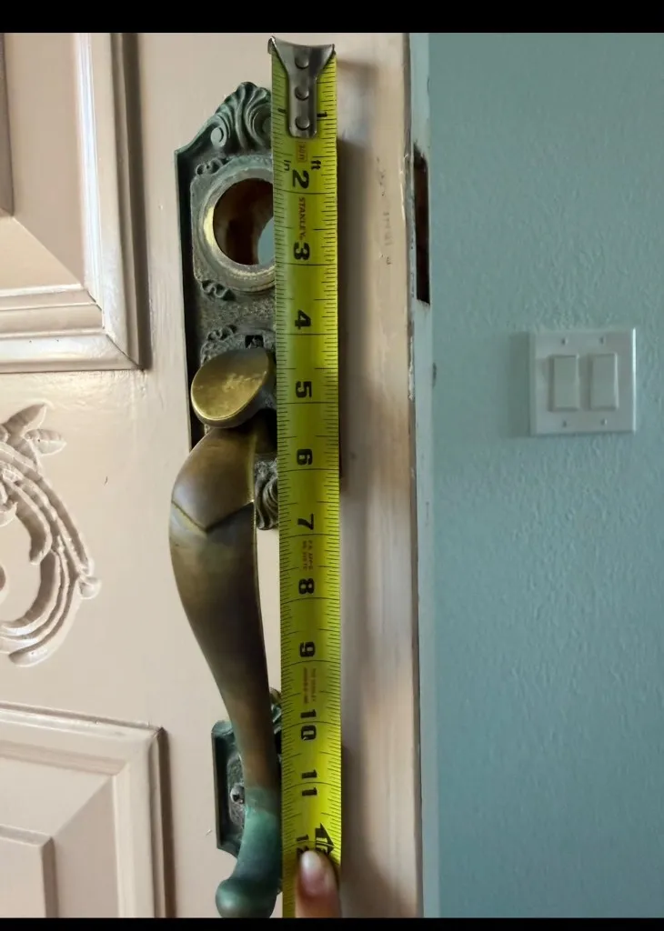 Worn brass entry handle with missing lock cylinder