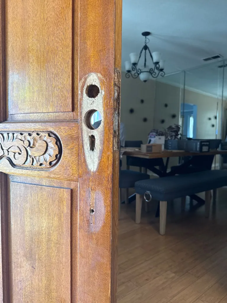 Wooden entry door prepared with sanded bore holes for new hardware